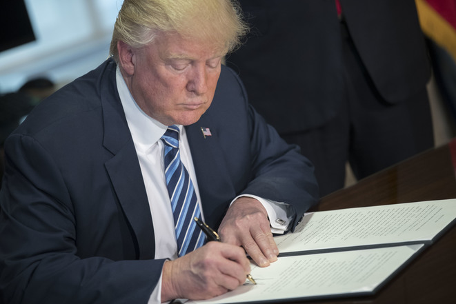 WASHINGTON, DC - APRIL 21: (AFP OUT) U.S. President Donald Trump signs a financial services Executive Order during a ceremony in the US Treasury Department building on April 21, 2017 in Washington, DC. President Trump is making his first visit to the Treasury Department for a memorandum signing ceremony with Secretary Mnuchin. (Photo by Shawn Thew - Pool/Getty Images)