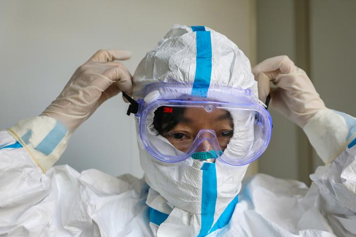 A doctor puts on protective goggles before entering the isolation ward at a hospital, following the outbreak of a new coronavirus in Wuhan, Hubei province, China January 30, 2020. Picture taken January 30, 2020.  China Daily via REUTERS  ATTENTION EDITORS - THIS IMAGE WAS PROVIDED BY A THIRD PARTY. CHINA OUT.