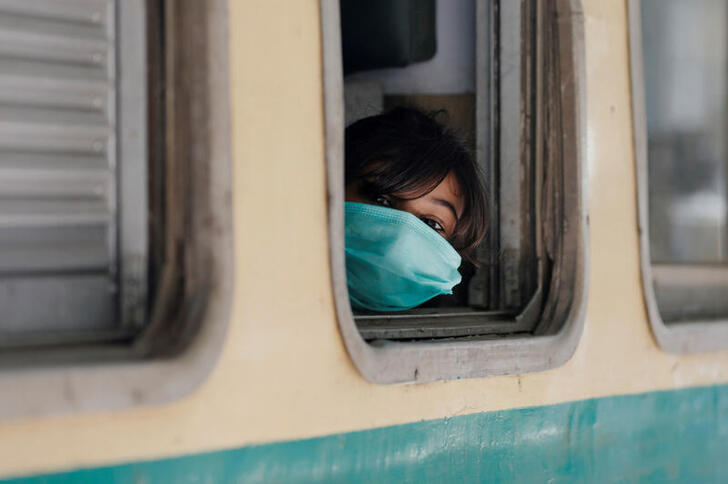 A girl wearing a protective mask looks out from a train window as she returns to her hometown, after Pakistan started easing the lockdown restrictions and allowed to resume passenger trains, following the coronavirus disease (COVID-19) outbreak, in Karachi, Pakistan May 20, 2020. REUTERS/Akhtar Soomro     TPX IMAGES OF THE DAY
