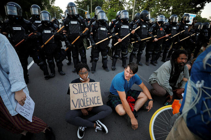 Protesters sit with their backs to riot policemen during nationwide unrest following the death in Minneapolis police custody of George Floyd, in Raleigh, North Carolina, U.S. May 31, 2020. Picture taken May 31, 2020. REUTERS/Jonathan Drake