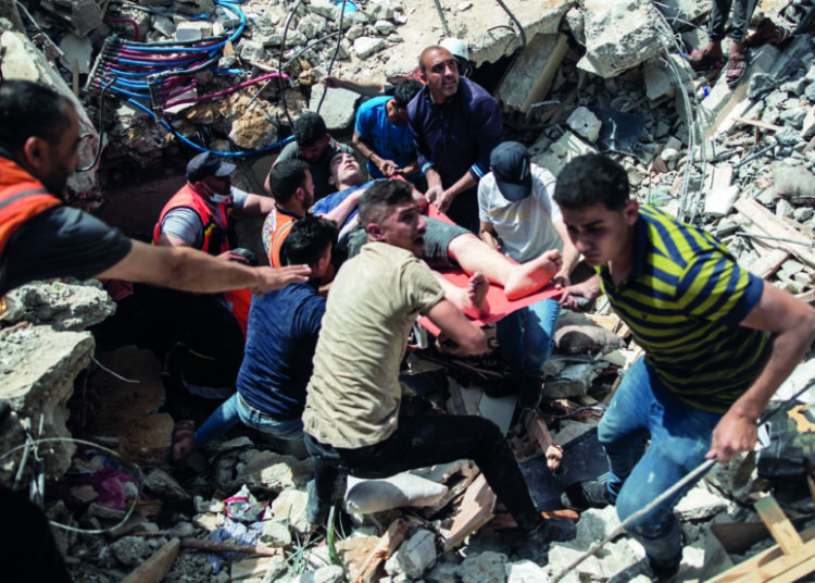 Palestinian rescue a survivor from under the rubble of a destroyed residential building following deadly Israeli airstrikes in Gaza City, Sunday, May 16, 2021. The Israeli airstrikes flattened three buildings and killed at least 26 people Sunday, medics said, making it the deadliest single attack since heavy fighting broke out between Israel and the territory's militant Hamas rulers nearly a week ago. (AP Photo/Khalil Hamra)